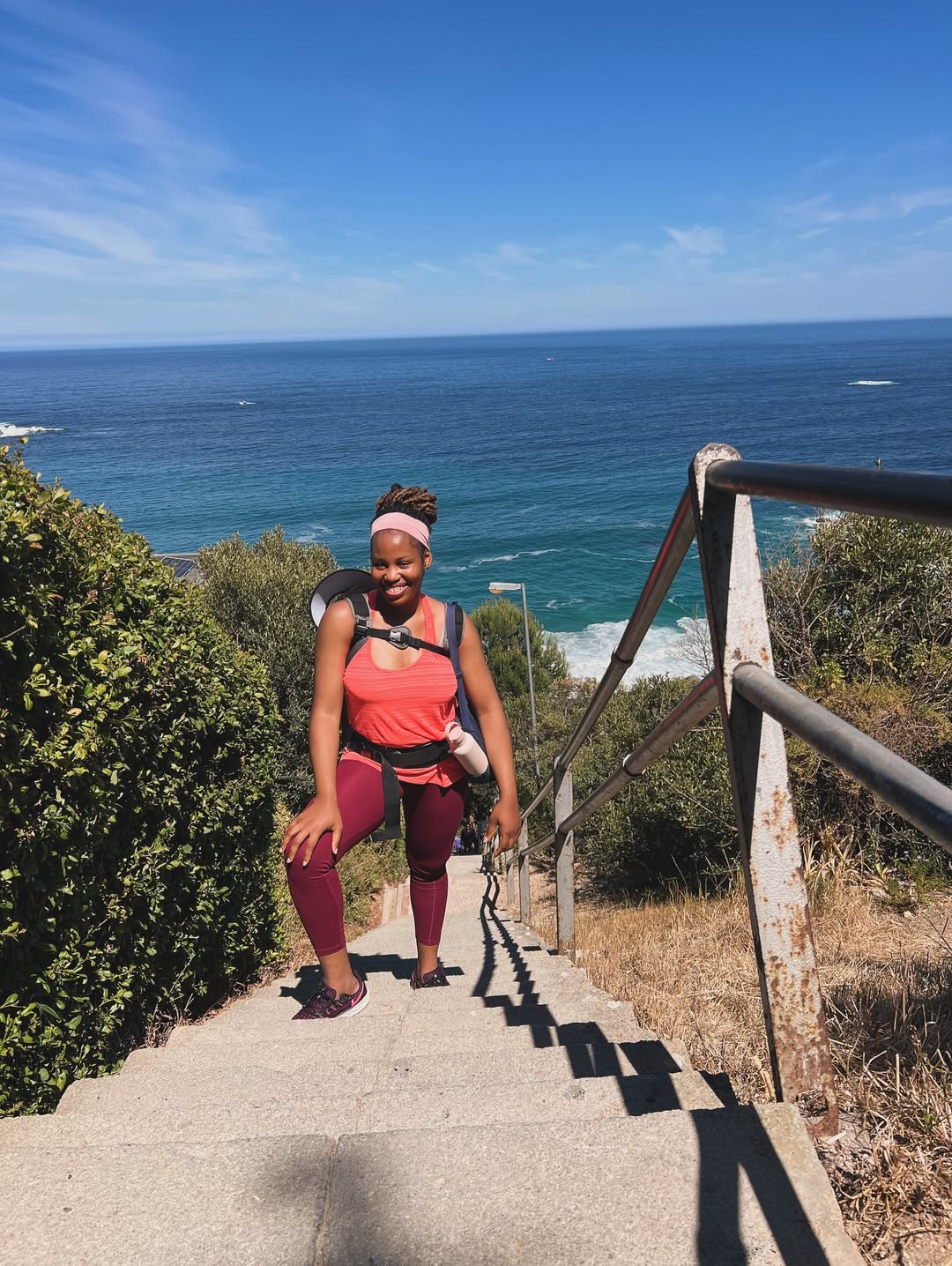 Sandra on the Cape Town sea stairs, smiling with her baby in a carrier